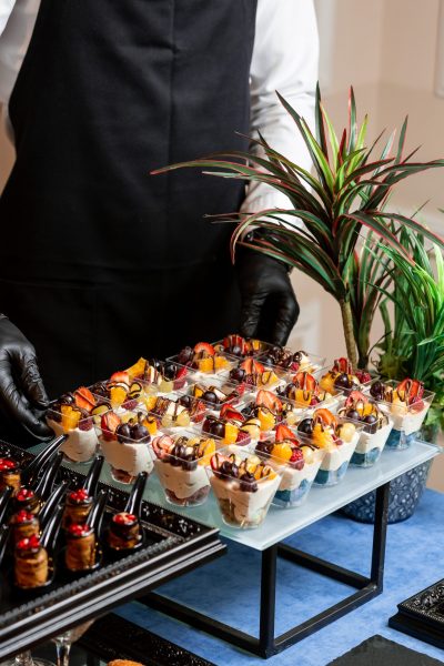 a cup of dessert with whipped cream, strawberries, cherries and orange